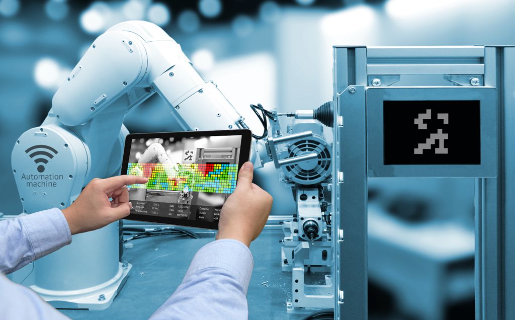 Tablet con interfaccia industriale che controlla un braccio robotico automatizzato